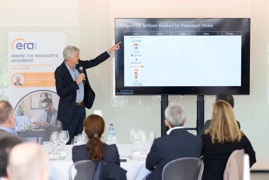 Profissional B2B a apresentar keynote em evento corporativo com plateia atenta, fotografia de alta qualidade para conteúdo LinkedIn