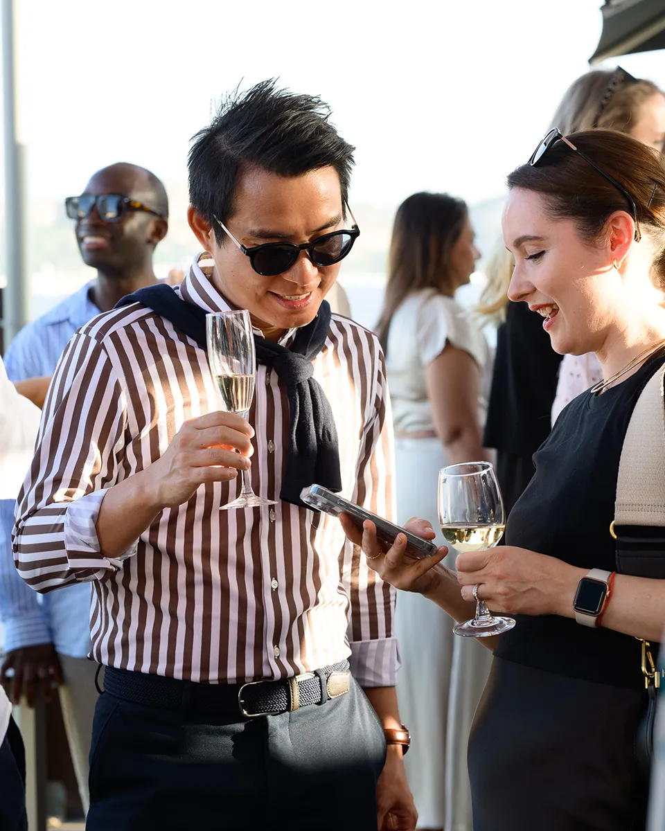 Profissionais a fazer networking durante pausa de conferência. Fotografia documental de ambiente empresarial.
